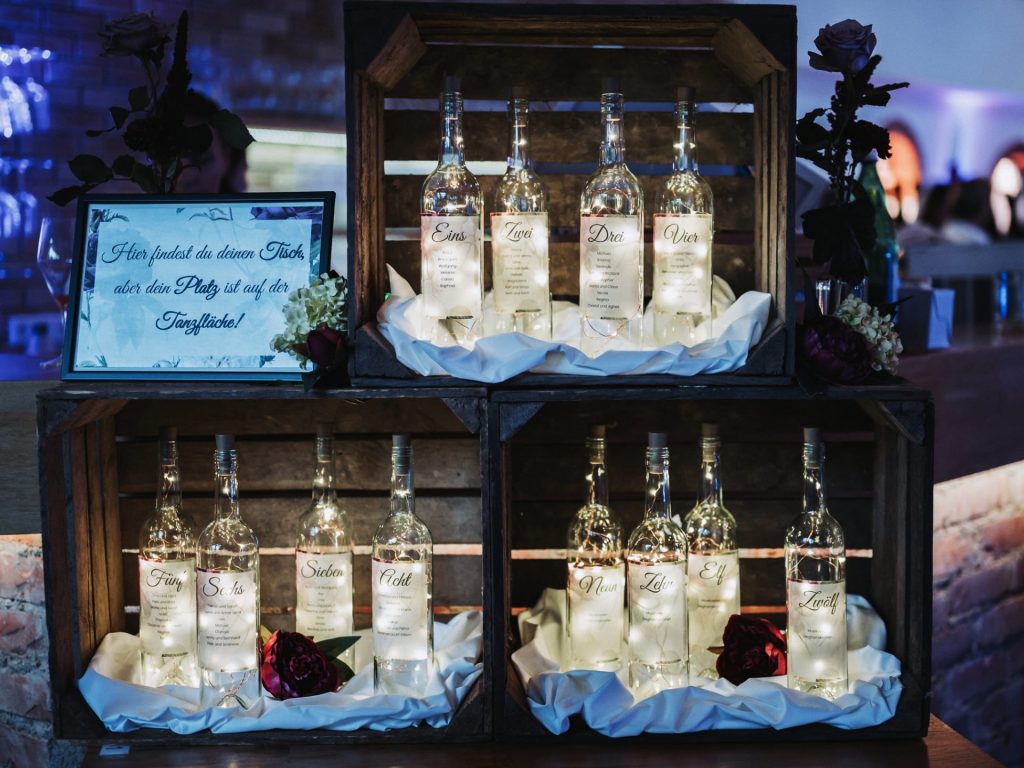 Weinetiketten für eine Hochzeit mit geschwungener Schrift und floralem Hintergrund