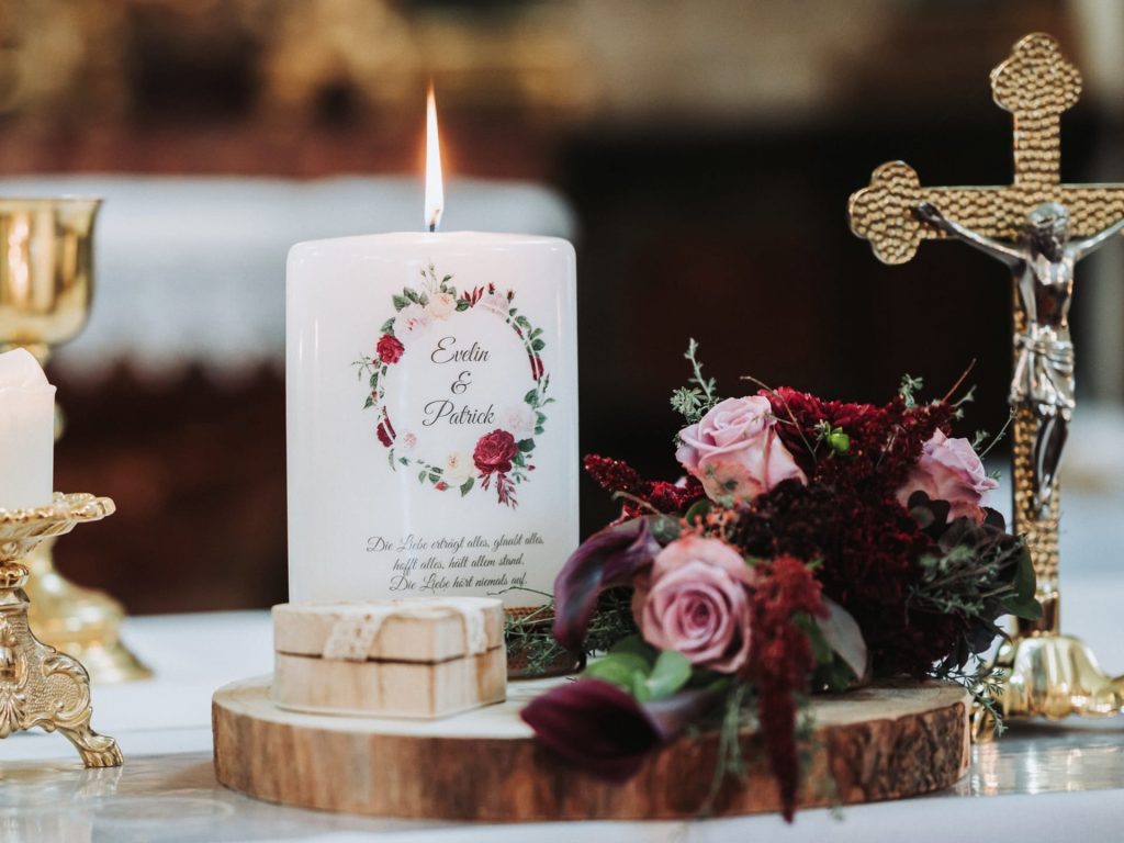 Grafikdesign einer Hochzeitskerze mit floralem Motiv und geschwungener Schrift